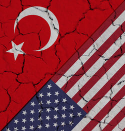 Directly above shot of american flag and turkish flag on cracked field