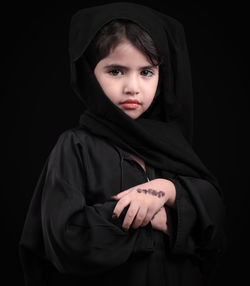Portrait of girl in burka against black background