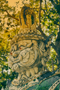 Close-up of angel statue against trees