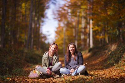 Young woman sitting in park during autumn