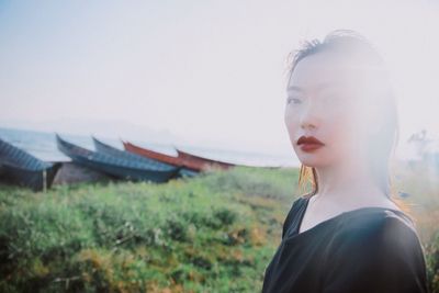 Close-up of young woman against sky