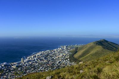 High angle view of cityscape by sea against clear sky