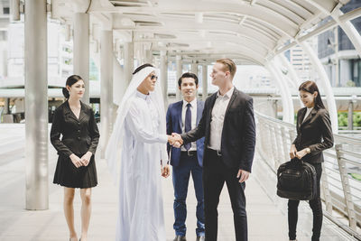 Business people standing on footbridge in city