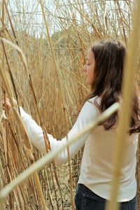 Side view of young woman standing on land