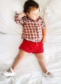 High angle view of girl sleeping on bed