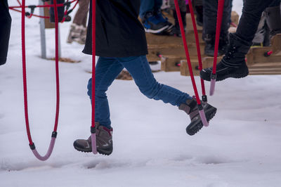 Low section of person playing at playground during winter