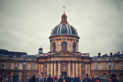 People at cathedral against sky