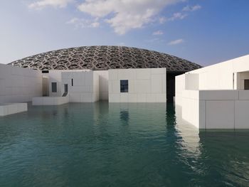 Building by swimming pool against sky