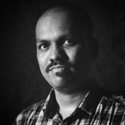 Close-up portrait of young man against black background