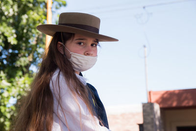 Little argentinian girl wearing face mask and hat