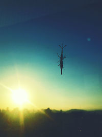 Silhouette of helicopter flying in sky