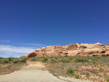 Scenic view of arid landscape against clear blue sky