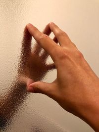 Midsection of woman touching wall