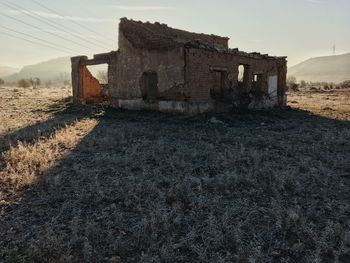 Old house on field against sky