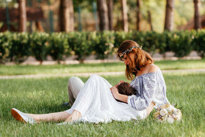 Side view of woman sitting on field