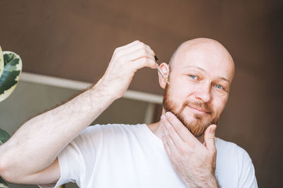 Portrait of young man drinking water against white background