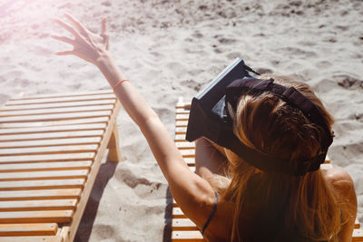 Rear view of woman photographing camera on beach