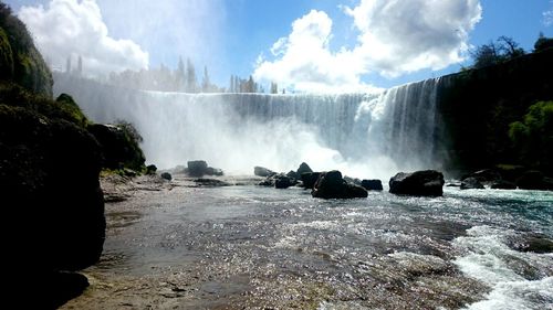 Panoramic view of waterfall against sky