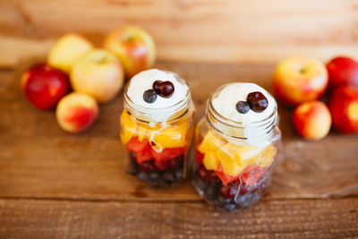 Jars with chopped fruit salad. mango, apple, grapes, blueberries and strawberries, with yogurt vegan