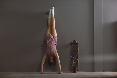 Woman exercising against wall 