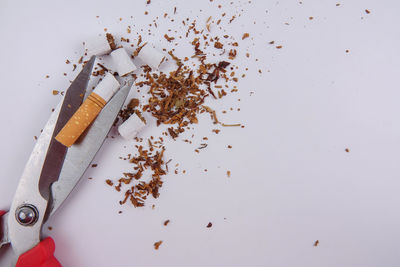 High angle view of cigarette on table against white background