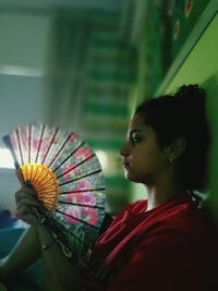 Close-up of woman holding fan