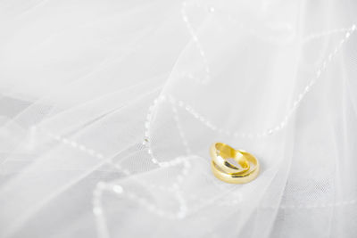 Close-up of wedding rings on white surface