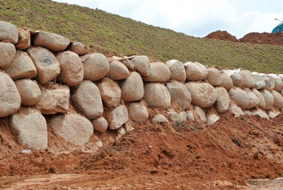 Stack of rocks on land against sky