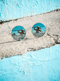 High angle view of sunglasses with reflection of woman wearing hat