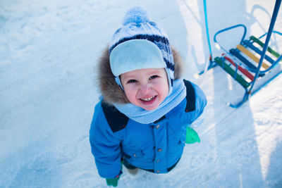 Portrait of happy boy playing in snow