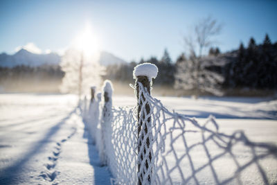 Close-up of snow on field against sky during winter