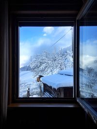 Scenic view of snowcapped mountains seen through window