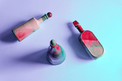 High angle view of painted bottles over colored background