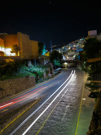 High angle view of light trails on street amidst buildings at night