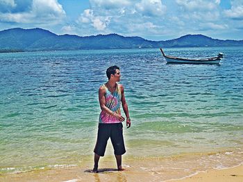 Woman standing on beach against sky