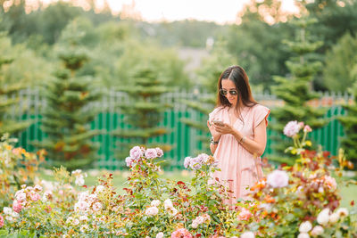 Close-up of woman standing by flowering plants