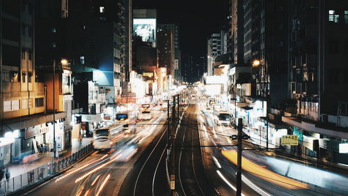 Vehicles on road along buildings at night