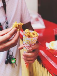 Midsection of man holding fried.
