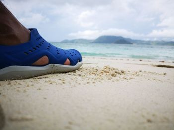 Low section of person relaxing on beach