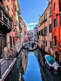 Boats moored on canal amidst buildings in city