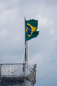 Low angle view of brazilian flag waving against sky