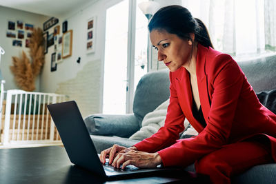 Woman using mobile phone while sitting on table