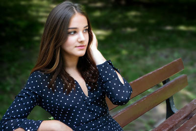 Portrait of young woman standing against plants