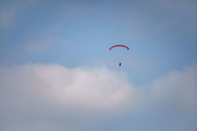 Low angle view of person paragliding against sky