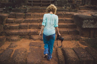 Rear view of boy walking against wall