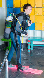 Smiling woman in diving suit walking on floor