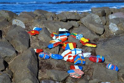 National flags painted on rocks by sea
