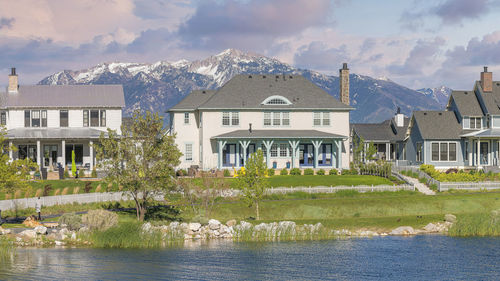 Houses by lake against sky