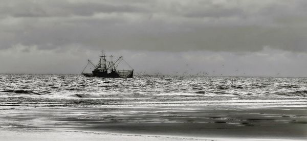 Sailboat in sea against sky