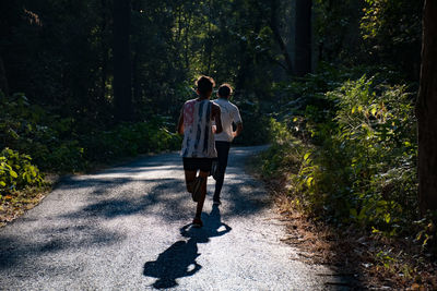 Rear view of couple walking on footpath